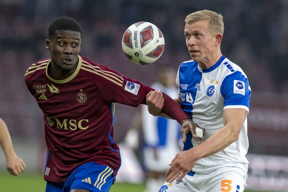 L&#039;attaquant genevois Chris Bedia, gauche, lutte pour le ballon avec le defenseur zurichois Joshua Laws, droite, lors de la rencontre de football de Super League entre le Geneve Servette FC et le  ...