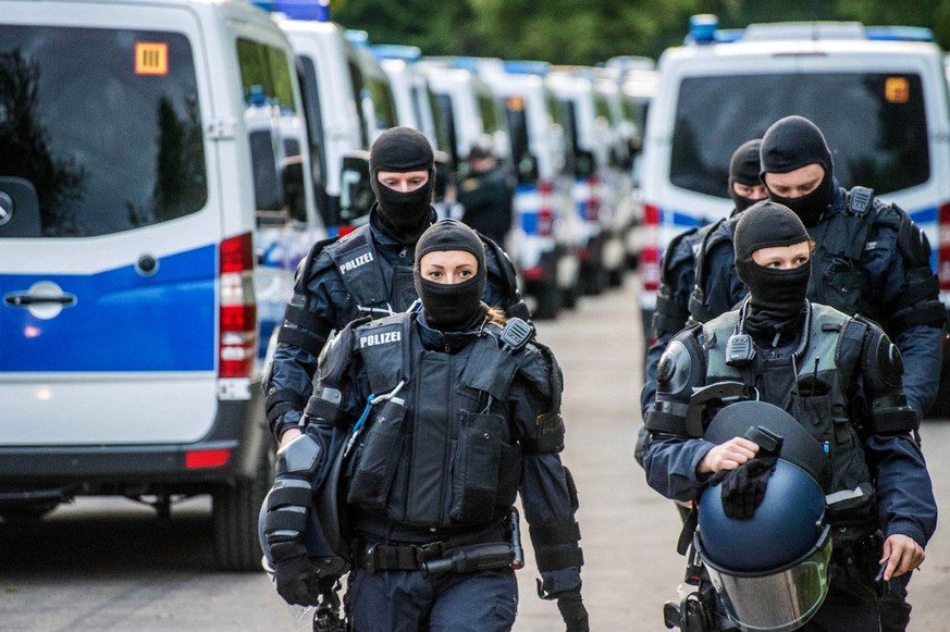 epa06708118 German police wearing masks at the reception center for refugees in Ellwangen, Germany, 03 May 2018. On the night of April 30, the police arrested a 23-year-old resident from Togo for a de ...