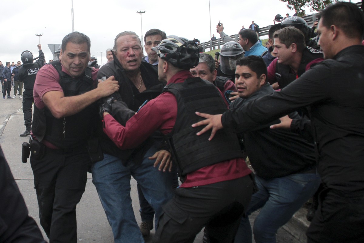 Sergio Berni, the security minister for the Buenos Aires province, center, is extracted from a protest in Buenos Aires, Monday, April 3, 2023. Berni was attacked during a protest by bus drivers after  ...