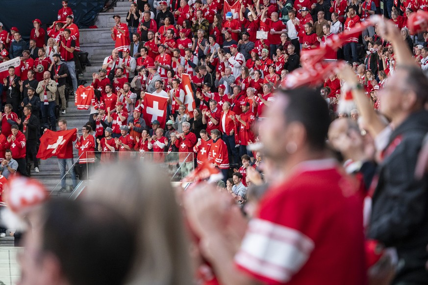 Swiss fans red and white wave flags and scarves to celebrate their team, during the 2026 IIHF Men's Ice Hockey World Championship preliminary round group A game between Switzerland and Great Brit ...