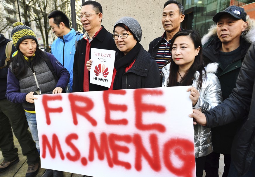 People hold a sign at a Vancouver, British Columbia courthouse prior to the bail hearing for Meng Wanzhou, Huawei&#039;s chief financial officer on Monday, December 10, 2018. (Jonathan Hayward/The Can ...