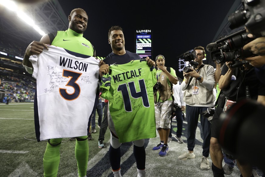 Seattle Seahawks wide receiver DK Metcalf, left, and Denver Broncos quarterback Russell Wilson, second from left, pose for a photo after they exchanged jerseys after an NFL football game, Monday, Sept ...