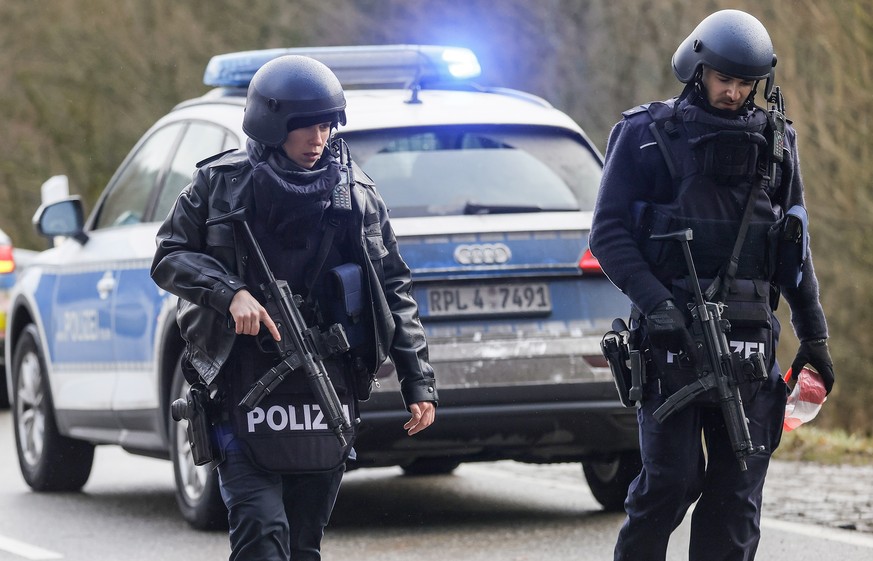 epa09719482 Police officers secure the crime scene in Ulmet, Germany, 31 January 2022. According to the police in Kaiserslautern, two police officers were shot during a routine traffic check in the di ...