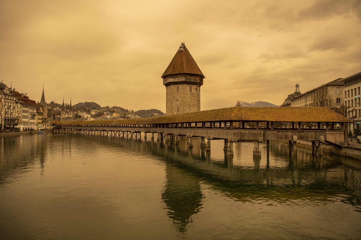 The Kapellbruecke (literally, Chapel Bridge) and the Wasserturm (Water Tower) in Lucerne appear in new colours, as Sahara sand colours the sky in orange and creates a special light atmosphere, Switzer ...