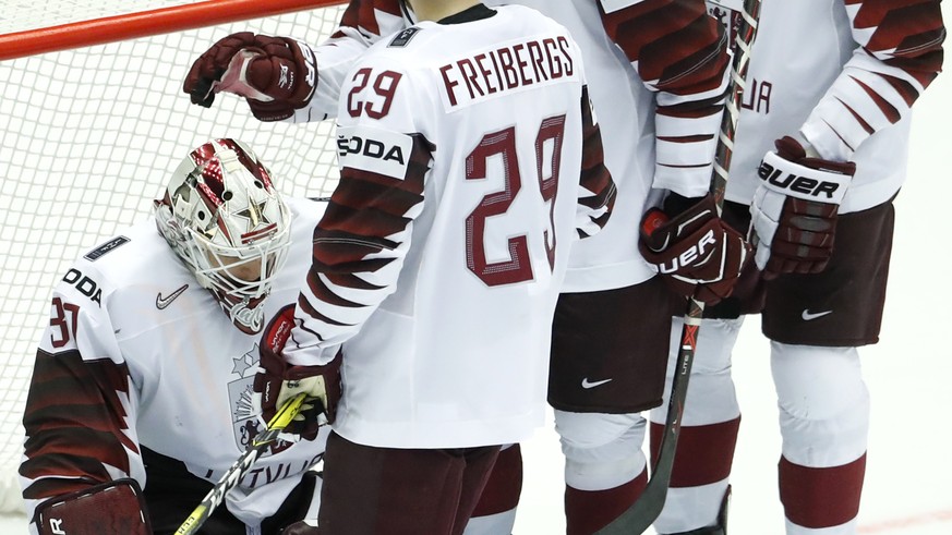 Latvia&#039;s goalkeeper Elvis Merzlikins is comforted by teammates after the Ice Hockey World Championships group B match between United States and Latvia at the Jyske Bank Boxen arena in Herning, De ...