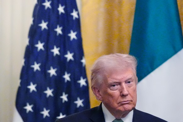 President Donald Trump listens during a shamrock presentation event with Irish Prime Minister Micheál Martin in the East Room of the White House, on St. Patrick's Day, Tuesday, March 17, 2026, in ...