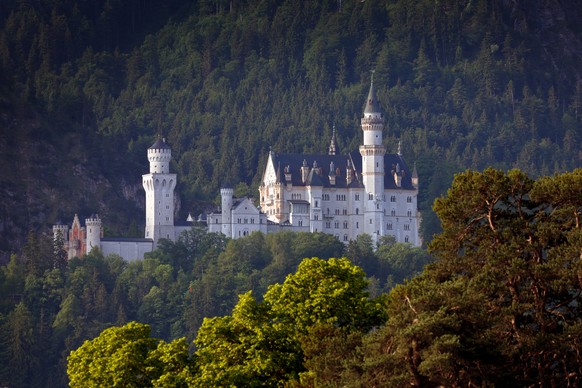 18.06.2023, Bayern, Schwangau: Das Schloss Neuschwanstein im Morgenlicht. Bei einem B