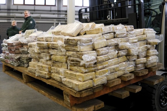 Custom investigators stand next to packages of cocaine on display at the customs office in Hamburg,, Germany, Friday, Feb. 3, 2017. A container carrying 717 kilograms (1,580 pounds) of cocaine which t ...