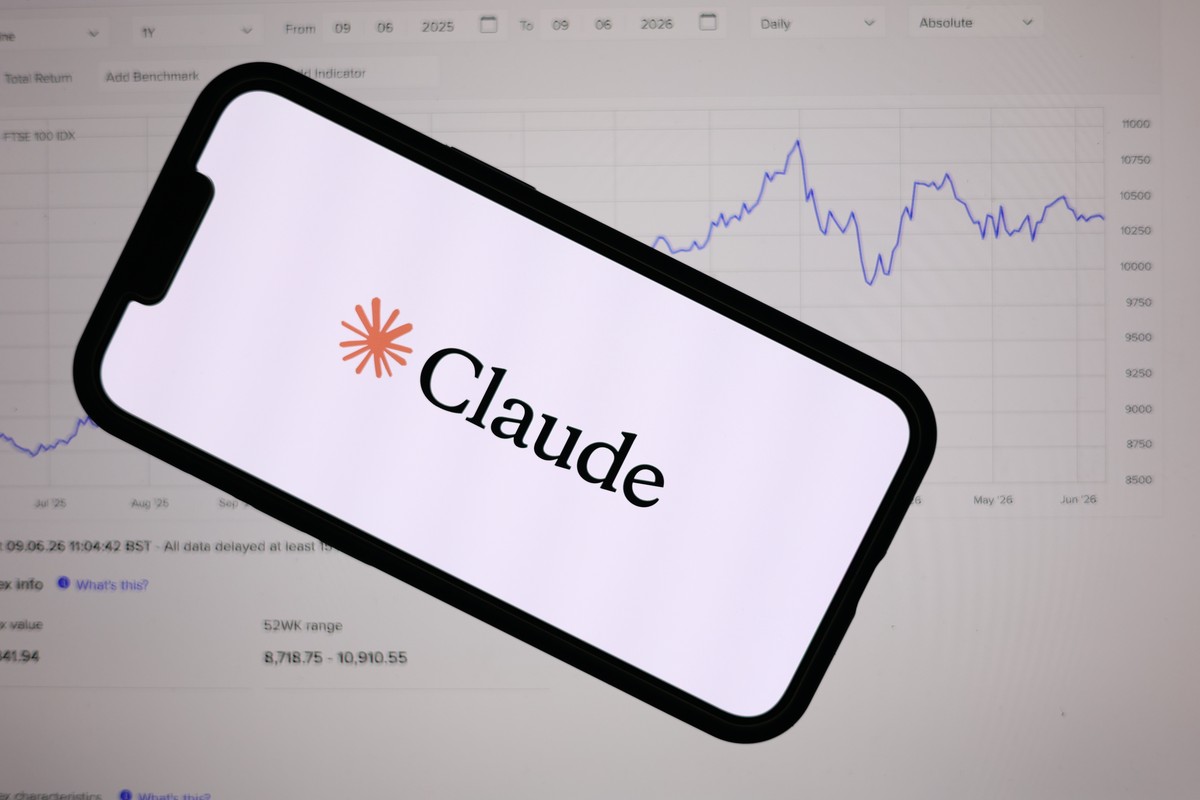 epa13026235 The Anthropic Claude logo is displayed on a mobile phone over a stock market graph displayed on a laptop screen in Liverpool, Britain, 09 June 2026. Leading AI (artificial intelligence) an ...