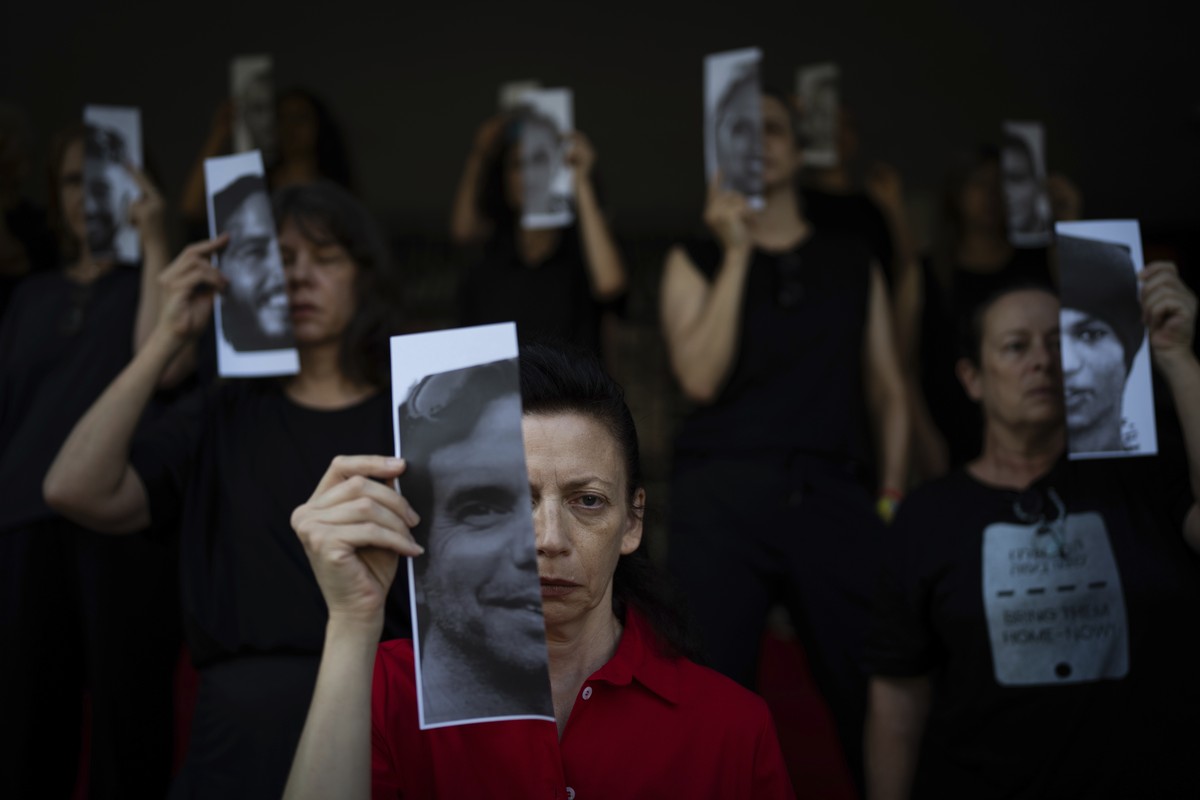 Relatives and supporters of Israeli hostages held by Hamas in Gaza hold photos of their loved ones during a performance calling for their return in Tel Aviv, Israel, Thursday, May 23, 2024. (AP Photo/ ...