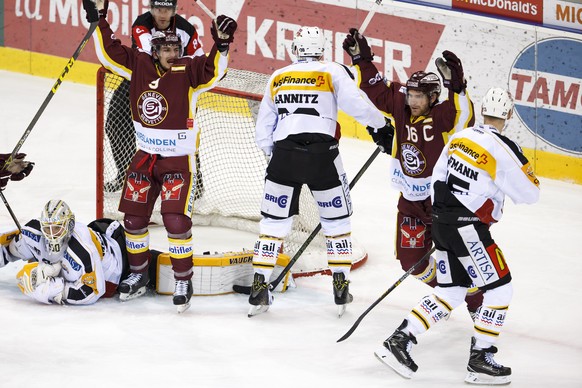 Geneve-Servette&#039;s center Jim Slater #16, of U.S.A., celebrates his goal past Lugano&#039;s goaltender Elvis Merzlikins, of Lativa, left, Geneve-Servette&#039;s forward Riat Damien, 2nd left, Luga ...