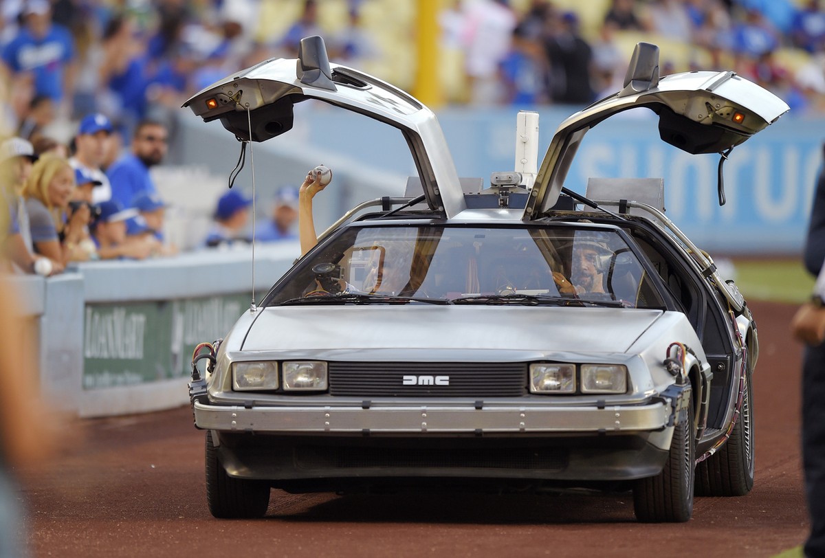 Actress Lea Thompson, left, rides onto the field in a customized DeLorean before throwing out the ceremonial first pitch prior to a baseball game between the Los Angeles Dodgers and the Cincinnati Red ...