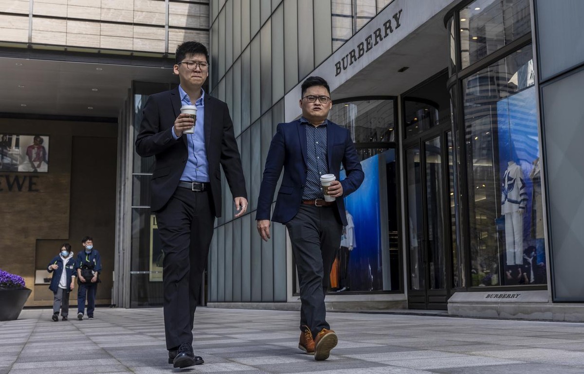 epa09098583 People walk in front off the Burberry store in Shanghai, China, 26 March 2021. Burberry is the first luxury brand that suffered Chinese backlash over Xingjiang. International clothing bran ...