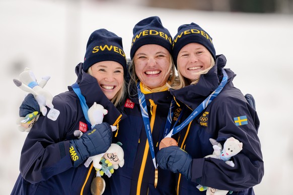 Gold medalist Linn Svahn, center, silver medalist Jonna Sundling, left, and bronze medalist Maja Dahlqvist, all three of Sweden, pose together after the cross-country skiing women's sprint classi ...
