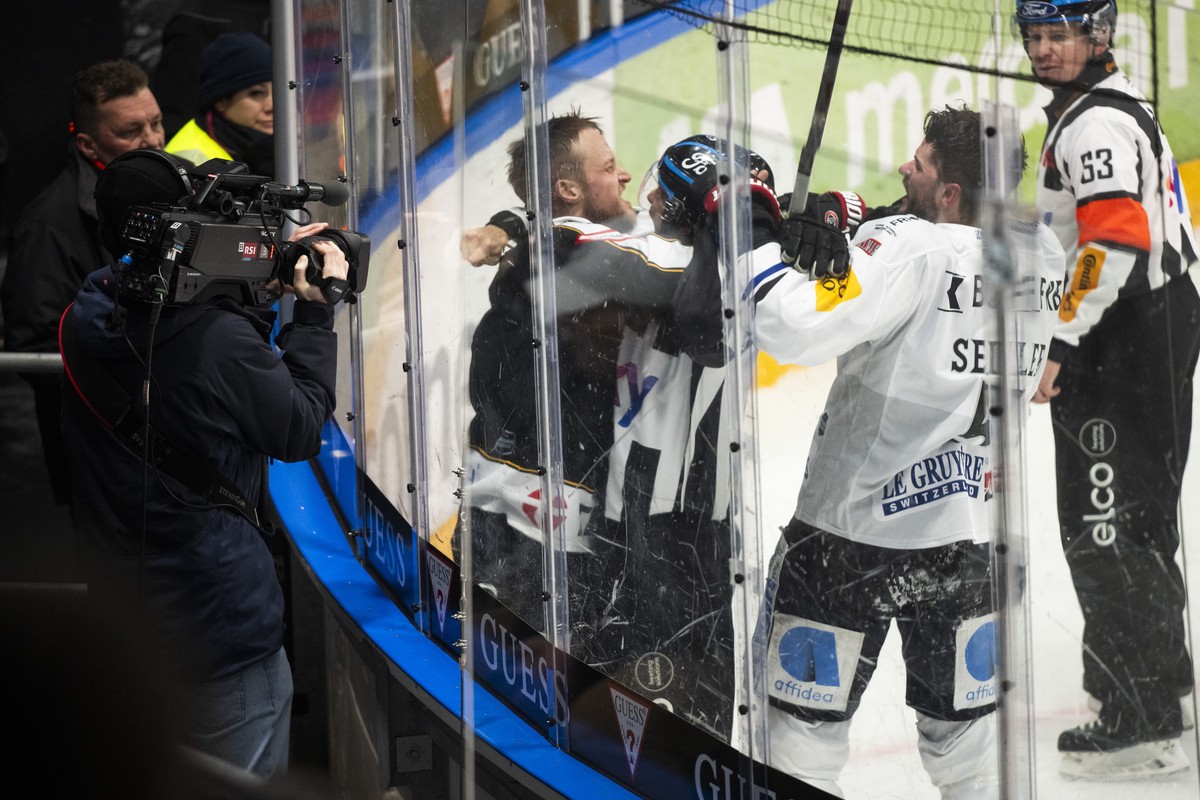 Left, Lugano?s player Calvin Thuerkauf fights with Fribourg?s player Simon Seiler, during the regular season of National League A (NLA) Swiss Championship 2024/25 between HC Lugano and Fribourg-Gotter ...