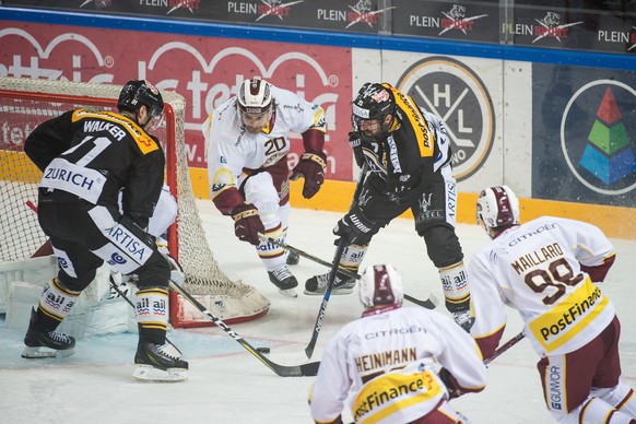 Lugano&#039;s player Julian Walker, Geneve-Servette&#039;s player Johan Fransson and Lugano&#039;s player Sebastien Reuille, from left, fight for the puck, during the preliminary round game of Nationa ...