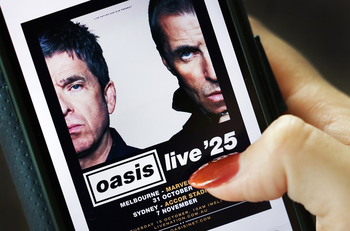 epa11649469 A mobile user looks over at the Oasis reunion tickets on the Oasis live 25 website, in London, Britain, 08 October 2024. Oasis have announced their reunion tour will travel to Australia, w ...