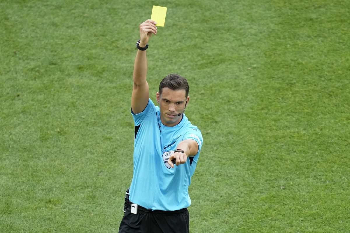 Referee Sandro Schaerer shows a yellow card to someone on the Slovenia bench during a Group C match between Slovenia and Denmark at the Euro 2024 soccer tournament in Stuttgart, Germany, Sunday, June  ...