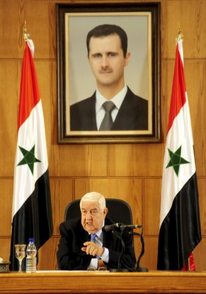 Syriens Aussenminister Walid al-Muallem. Im Hintergrund ein Gemälde mit dem Konterfei des Präsidenten Baschar al-Assad.