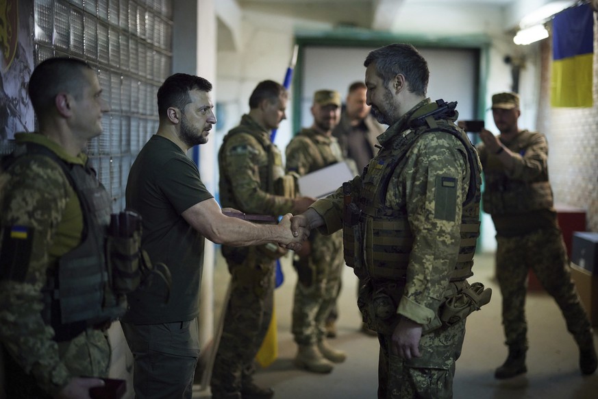 In this photo provided by the Ukrainian Presidential Press Office, Ukrainian President Volodymyr Zelenskyy, second left, praises servicemen close to the front line in Donetsk region, Ukraine, Sunday,  ...