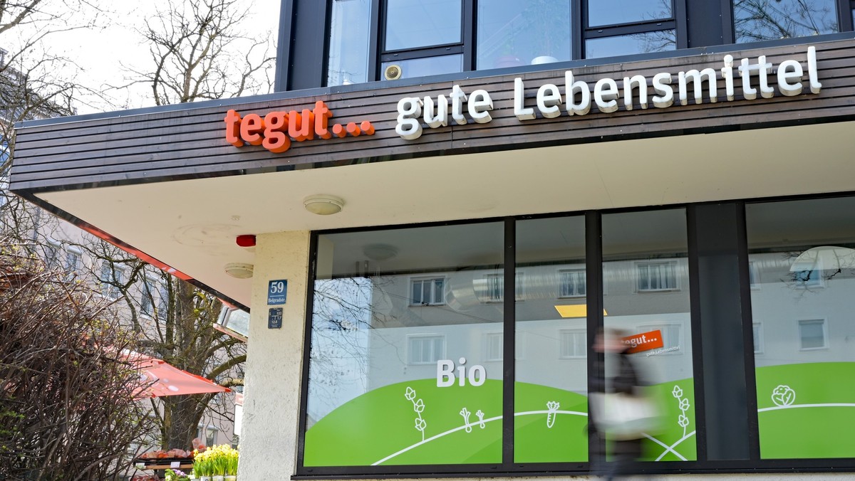 ARCHIV - 18.03.2026, Bayern, München: Eine Person läuft an einer tegut-Filiale vorbei. Der bisherige Eigentümer der Kette, der Schweizer Handelskonzern Migros, will sich aus Deutschland zurückziehen.  ...