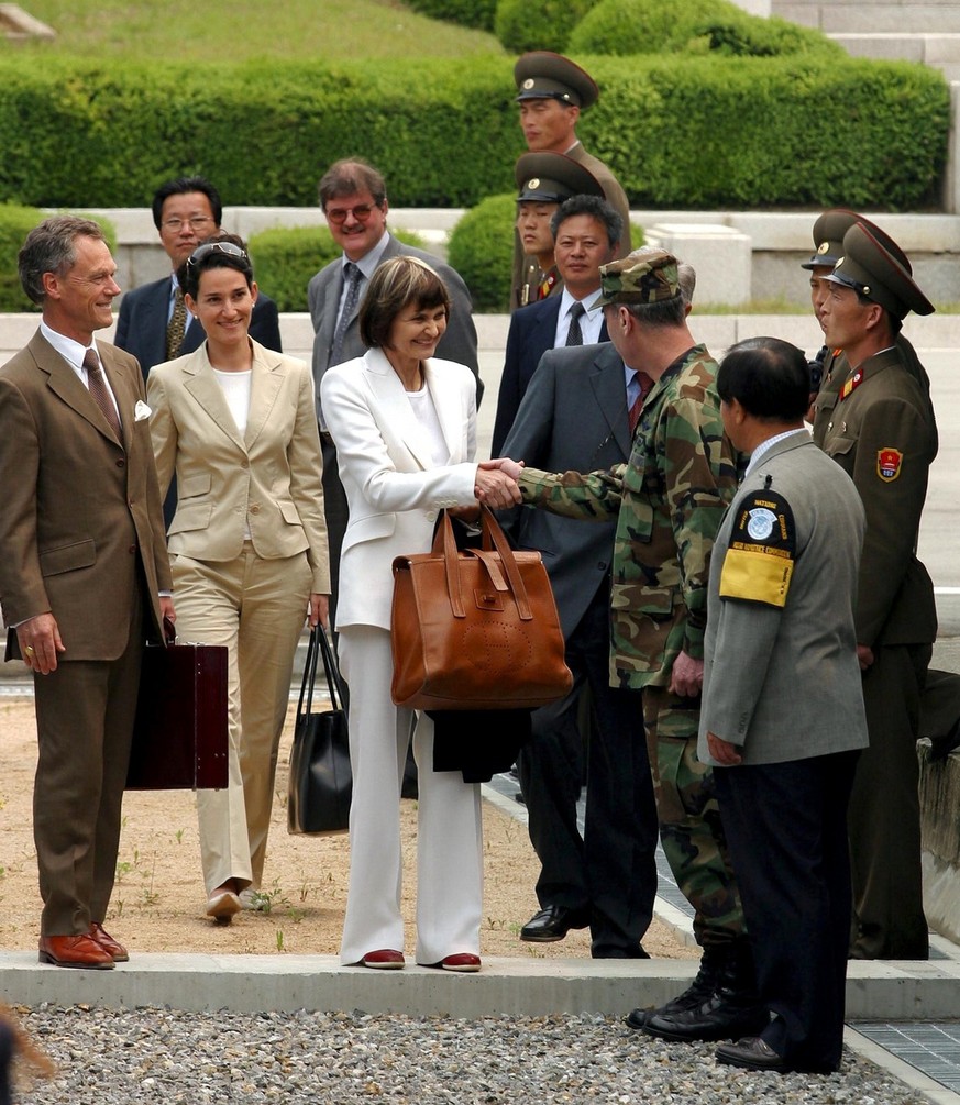 Switzerland&#039;s Foreign Minister Micheline Calmy-Rey, center, is greeted by a South Korean soldier as she stands on the border line between North Korea and South Korea at the truce village of Panmu ...