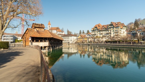 Thun, Switzerland, February 13, 2023 Historic old wooden bridge across the Aare river at the water promenade in the city center xkwx thun, switzerland, travel, tourism, city, downtown, sightseeing, ex ...