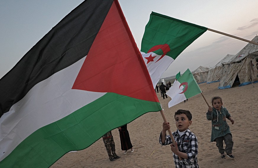 epa06636315 Palestinians children hold up a Palestinian and Algerian flags during preparation for mass protests along the border between Israel and Gaza Strip, in the eastern Beit Hanun towm in the no ...