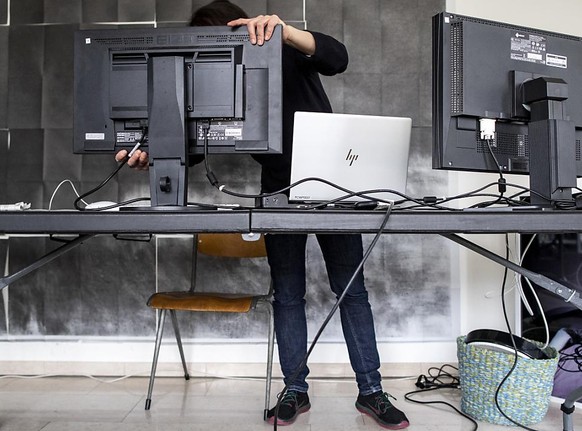 Eine Frau installiert zu Hause in Zürich ein Heimbüro. (Archivbild zu Home office, Homeoffice)