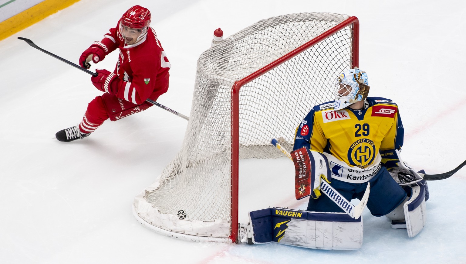 L&#039;attaquant lausannois Denis Malgin, gauche, marque le deuxieme but au gardien davosien Sandro Aeschlimann, droite, lors du match du championnat suisse de hockey sur glace de National League entr ...