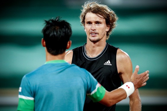 epa09252189 Alexander Zverev (R) of Germany reacts after winning his fourth round match against Kei Nishikori (L) of Japan at the French Open tennis tournament at Roland Garros in Paris, France, 06 Ju ...