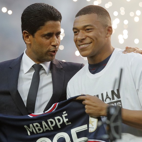 PSG President Nasser Al-Khelaifi, left, speaks to PSG&#039;s Kylian Mbappe who holds a shirt with his name and 2025 on it as it is announced he has signed a three year extension to his contract on the ...