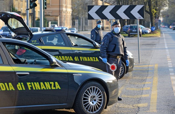 epa08338279 Italian Guardia di Finanza (Finance Police) officers wearing protective masks verify the legitimacy of the movements of some motorists, in compliance with the DCPM issued for the containme ...