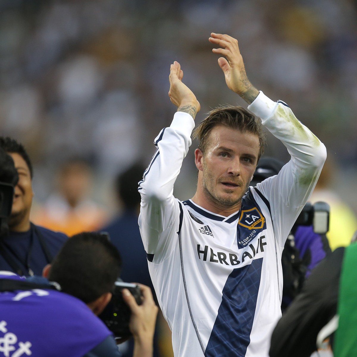 Los Angeles Galaxy's David Beckham, of England, acknowledges the fans as he leaves the field after the team's 3-1 win in the MLS Cup championship soccer match against the Houston Dynamo in C ...