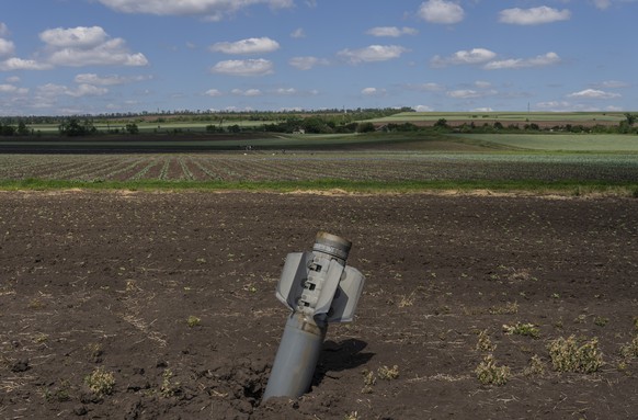 An unexploded Russian rocket lays on a field near Soledar, eastern Ukraine, Monday, June 6, 2022. (AP Photo/Bernat Armangue)