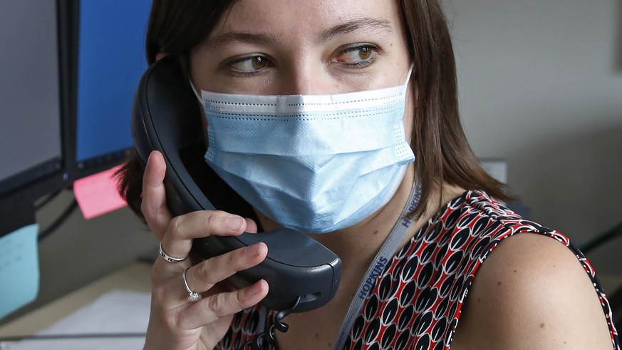 In this Tuesday, May 19, 2020, photo, health investigator Mackenzie Bray sits in her office at the Salt Lake County Health Department in Salt Lake City. Bray normally works to track contacts for peopl ...