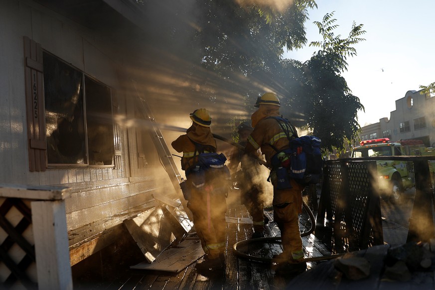 Firefighters spray water into a damaged building while battling the Clayton Fire near Lower Lake in California, U.S. August 14, 2016. REUTERS/Stephen Lam