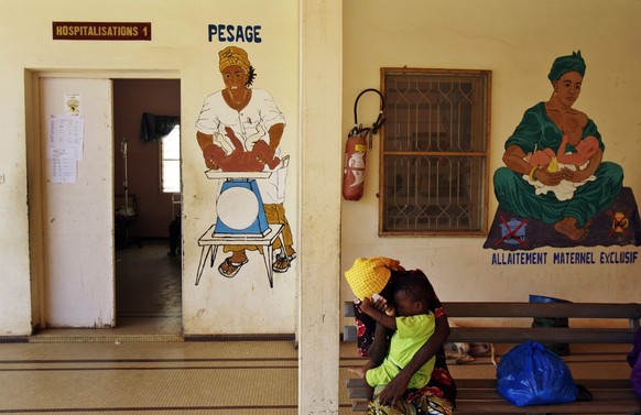 Eine Frau und ihr Kind warten vor einer Frauenklinik in Dakar, Senegal.