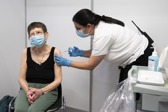 Die 80-jaehrige Beatrice Lewy erhaelt als erste Person im Kanton Basel-Stadt eine Impfung gegen Corona, am Montag, 28. Dezember 2020, im Impfzentrum Basel Stadt in Basel. (KEYSTONE/Peter Klaunzer)