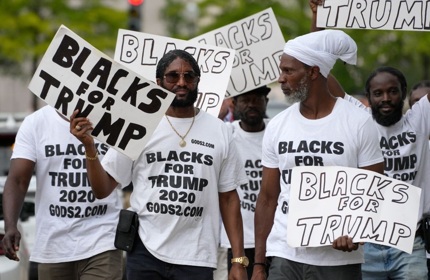 WASHINGTON, DC - AUGUST 03: Black supporters of former U.S. President Donald Trump carry signs in front of the E. Barrett Prettyman United States Courthouse on August 03, 2023 in Washington, DC. Forme ...