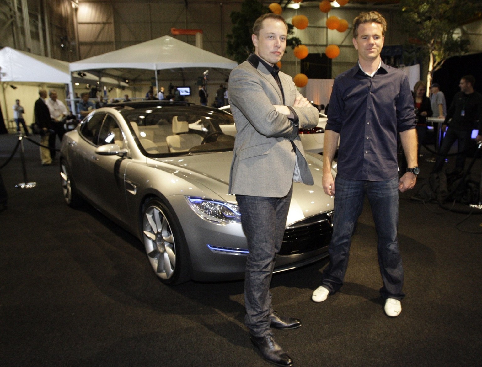 Tesla Motors CEO, Chairman and Product Architect Elon Musk, left, and chief designer Franz von Holzhausen, pose for photos at the unveiling of the Tesla Model S all-electric 5-door sedan, in Hawthorne ...