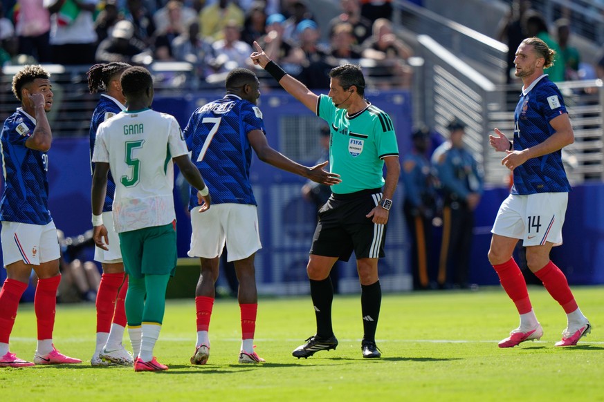 Referee Alireza Faghani, gestures as France's Ousmane Dembele (7) argues during the World Cup Group I soccer match between France and Senegal in East Rutherford, N.J., near New York, Tuesday, Jun ...