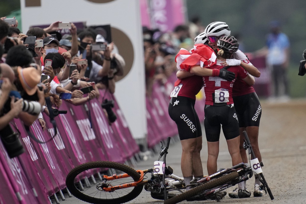 Jolanda Neff of Switzerland hugs teammates Sina Frei (8) who won silver, and Linda Indergand (19) who won bronze, for a sweep of the podium for Switzerland, at the finish line the women's cross-c ...