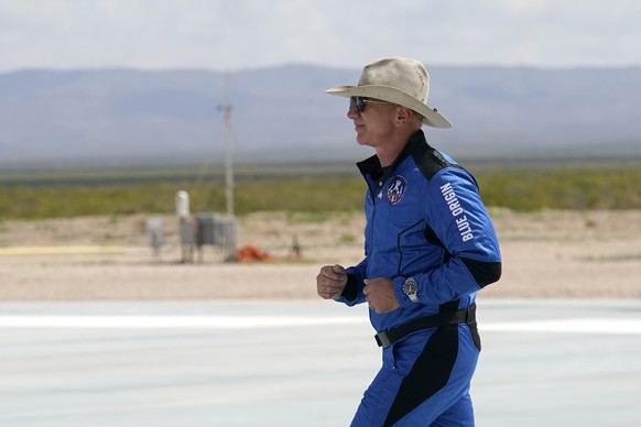 Jeff Bezos, founder of Amazon and space tourism company Blue Origin jogs onto the Blue Origin&#039;s New Shepard rocket landing pad to pose for photos at the spaceport near Van Horn, Texas, Tuesday, J ...