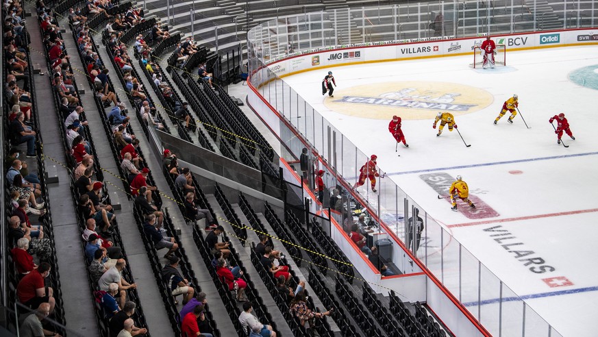 Les spectateurs lausannois masques regardent le match amical de preparation pour la nouvelle saison de hockey sur glace National League entre Lausanne HC, LHC et le EHC Biel-Bienne le vendredi 21 aout ...
