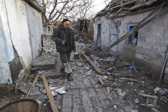 epa09774802 Local resident Valery walks around a damaged homestead as a result of shelling in Tamarchuk village near Marinka not far from pro-Russian militants controlled city of Donetsk, Ukraine, 20  ...