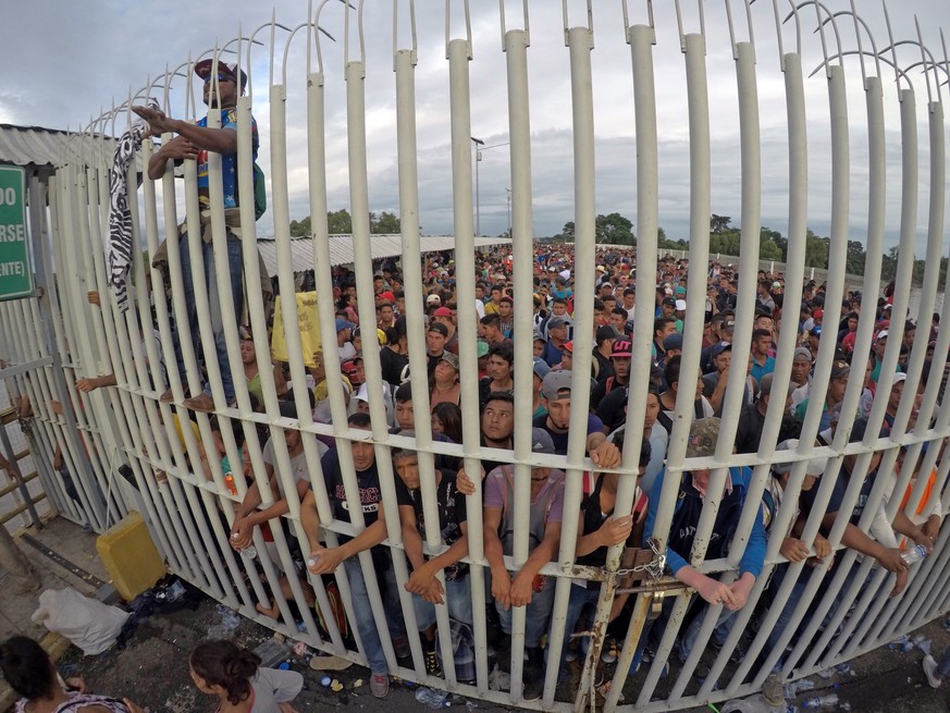 epa07105915 Honduran migrants await access on the bridge that crosses the Suchiate River after crossing the fence on the border with Guatemala to enter Mexico, in Ciudad Hidalgo, Mexico, 19 October 20 ...