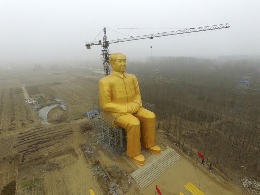 A crane is seen next to a giant statue of Chinese late chairman Mao Zedong under construction near crop fields in a village of Tongxu county, Henan province, China, January 4, 2016. REUTERS/Stringer/F ...