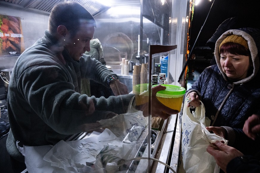 Veterans of the 3rd Separate Assault Brigade of Ukraine's Armed Forces serve free hot meals in a residential neighborhood for people without power in their homes after repeated Russian air attack ...