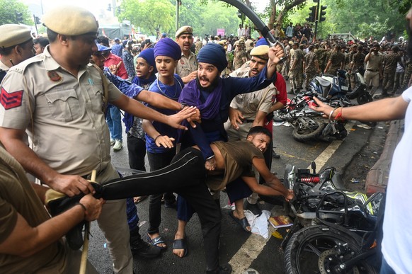Supporters of the Cockroach Janta Party scuffle with police as they attempt to march toward India's Parliament, demanding the resignation of the education minister, in New Delhi, Monday, July 20, ...